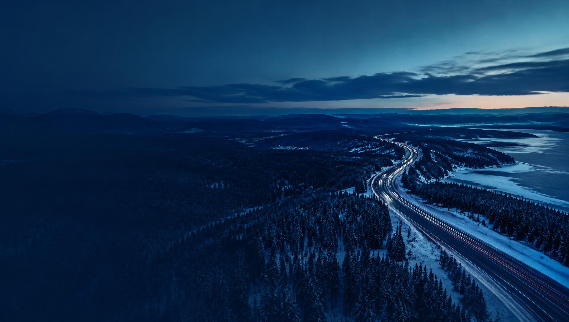 Route traversant une forêt québécoise au crépuscule